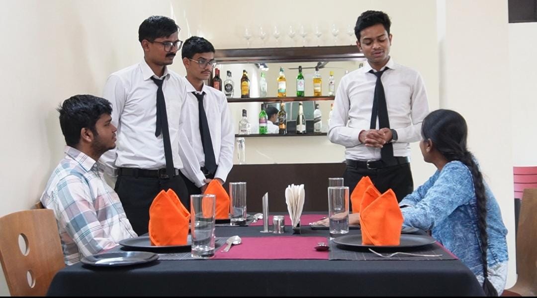 A service briefing at a laid table in the training restaurant at School of Hospitality & Management, Durgapur