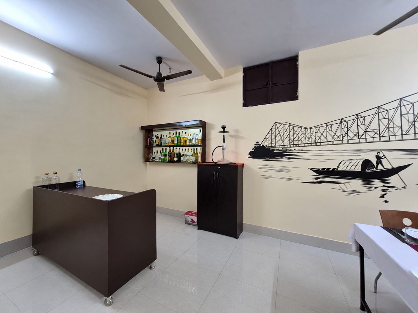 The food and beverage service lab at School of Hospitality & Management, Durgapur, with the mock bar and the Howrah Bridge mural behind it