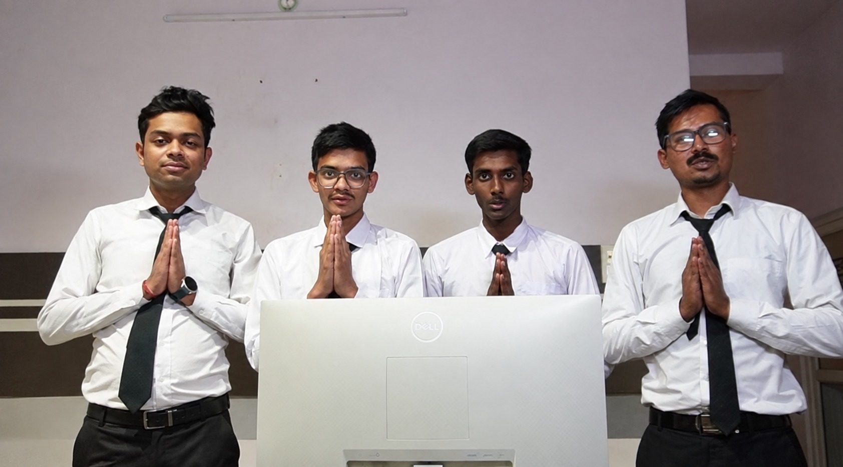Students in service uniform greeting a guest at the front office training desk at School of Hospitality & Management, Durgapur