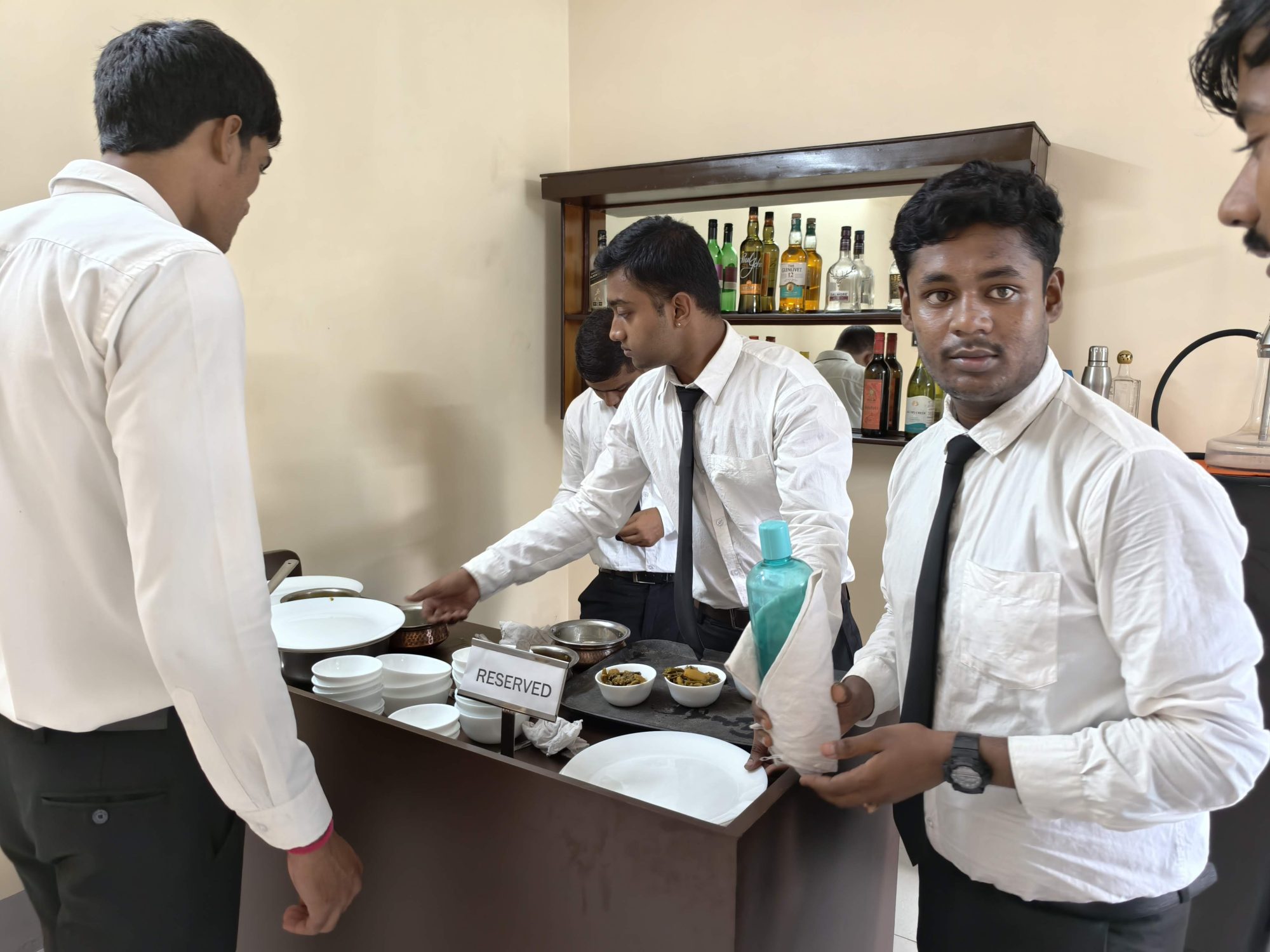 Students working the service station beside the mock bar during food and beverage service training at SHM Durgapur